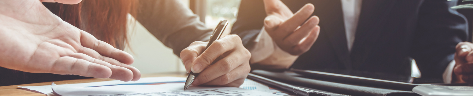 A person writing their signature on a document.